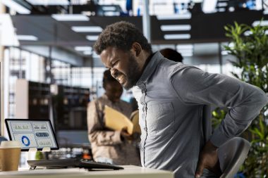 African american business analyst deals with back pain and muscle cramps Formation Gestes et Postures